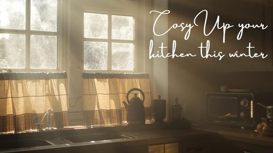 Cosy British kitchen with linen café curtains filtering soft winter light through a bay window, decorated for Christmas warmth.